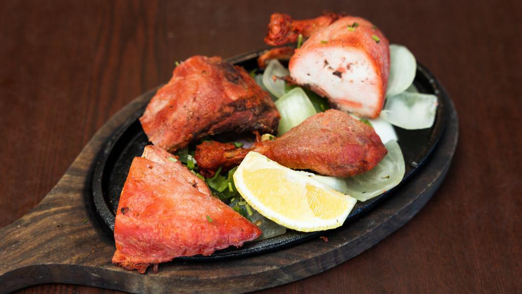 Tandoori Chicken · Kebab of chicken pieces (with bone) marinated in yogurt, ginger, garlic, lemon juice and spice, cooked to perfection.