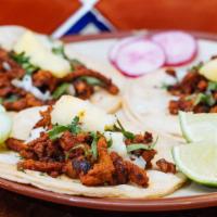 Al Pastor Taco · Three pieces. Pork marinated in pineapple juice, guajillo peppers, and achiote. Served with ...