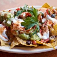 Regular Nachos · Crispy tortillas chips covered with melted cheese and either black or pinto beans. Served wi...