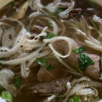 Dac Biet  · Gluten free. Bowls of Vietnamese beef noodle soup with sliced onion, scallion, and cilantro,...