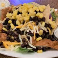 Southwest Chicken Salad · Grilled blackened chicken, crisp tortilla strips, black beans, corn, tomatoes and cheese on ...