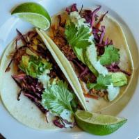 Carnitas Taco · braised pork, cabbage slaw, avocado, red onion & cilantro crema