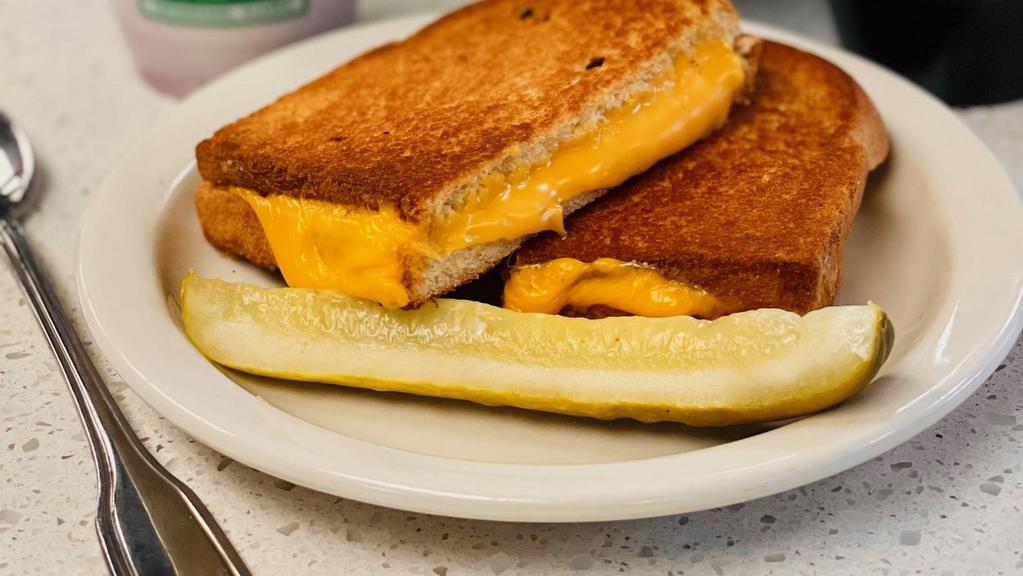 Grilled Cheese · Three slices of American cheese served with a pickle wedge.