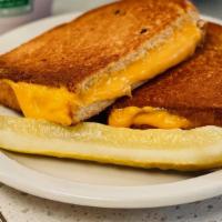 Grilled Cheese · Three slices of American cheese served with a pickle wedge.