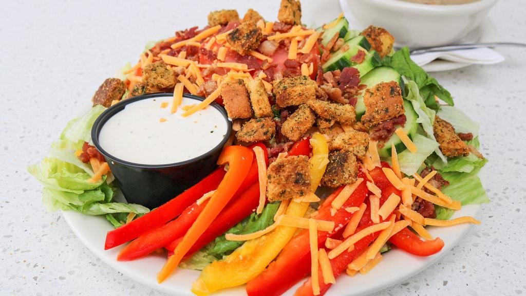 Bacon Ranch Salad · A blend of iceberg and romaine lettuce, cucumber, red pepper, shredded cheddar cheese, tomato, bacon, our homemade croutons served with our signature ranch dressing.