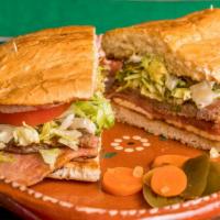 Torta Campechana · Special torta, toasted and filled with ham and steak, Mexican white cheese, mayo, lettuce, t...