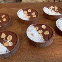 Chocolate Hazelnut Tart · Valrhona Chocolate tart shell filled with a rich brownie hazelnut.