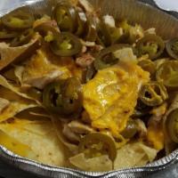 Nachos · A skillet of crispy corn tortillas with mixed cheese, homemade refried beans, tomatoes, blac...