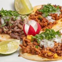 Tacos Al Pastor · Marinated pork meat with pineapple. Topped with onion and cilantro.
