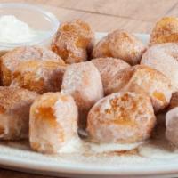 Cinna-Bites · Our dough cut into bite-sized pieces, topped with butter, sugar and cinnamon, served with ic...