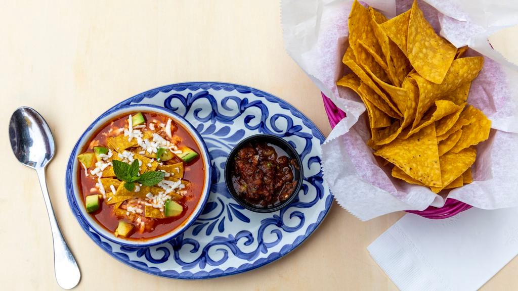Chicken Tortilla Soup · Mexican soup with grilled chicken, crispy tortilla strips, avocado, Mexican rice and Cotija cheese.