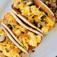 Betty Tacos · Two bacon Bettys filled with scrambled eggs, breakfast sausage & cheddar.