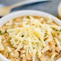 White Chicken Chili · Fresh chicken chili made with tomatillos, white beans, and cilantro, topped with aged white ...