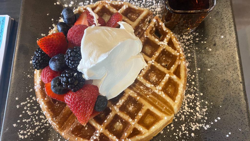 Belgian Waffle With Mixed Berries · belgian waffle with mixed berries and maple syrup topped with powdered sugar
