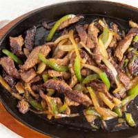 Zilzil Tibs · Strips of beef tenders sate'd  on cast iron skillet  with onions and pepper and seasonings.