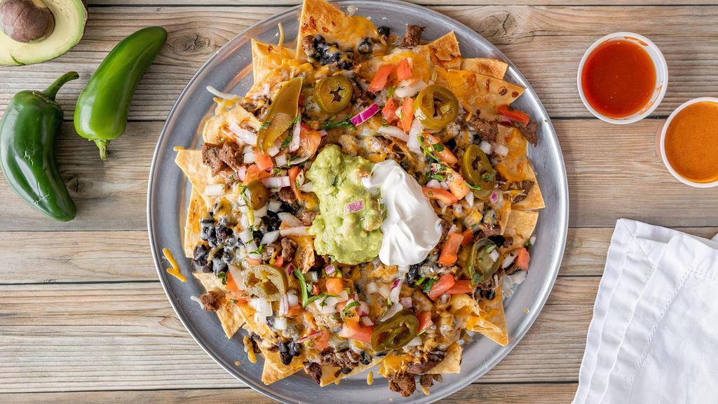 Super Nachos · TORTILLA CHIPS TOPPED WITH YOUR CHOICE OF MEAT OR VEGETARIAN,BEANS, RED ENCHILADA SOUCE, PICO DE GALLO, GUACMOLE, CHEESE, JALAPENOS AND SOUR CREAM.