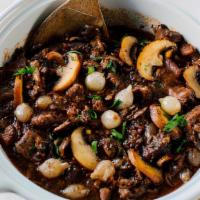 Beef Bourguignon With Italian Bread And Parmesan Garlic Dipping Oil - Large · Tender steak braised in a red wine sauce surrounded by mushrooms, pearl onions, and bacon. E...