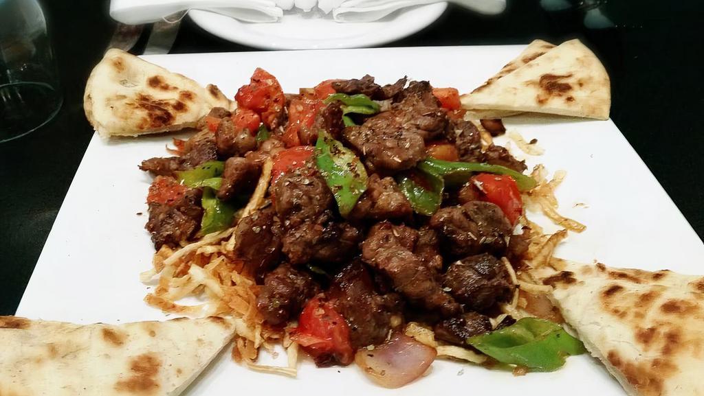 Çoban Kavurma · Sautéed, steel roasted lamb cubes with onions, green peppers, tomatoes, and oregano. Served over straw potatoes.