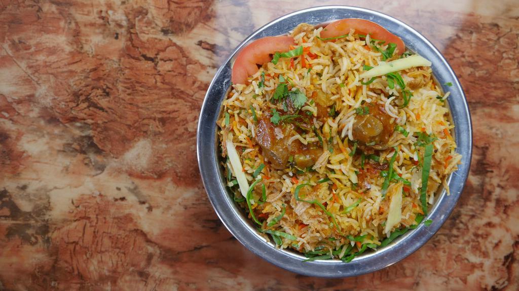Goat Biryani · Saffron flavored basmati rice cooked with pieces of goat, over low fire with Indian herbs. Served with homemade raita.