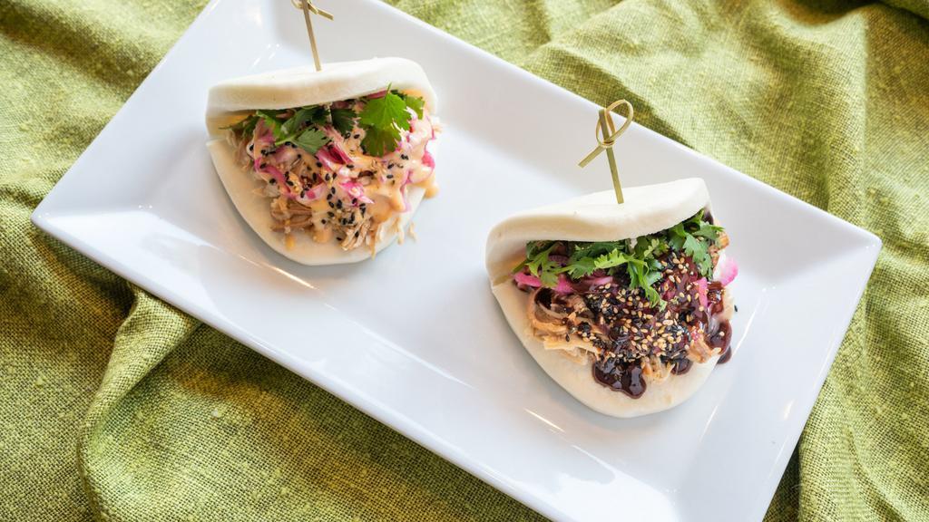 Chicken Bao Buns · Two steamed buns with marinated shredded chicken, pickled red onion, cilantro and choice of sauce.