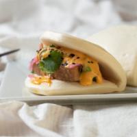 Pork Belly Bao Buns · Two steamed buns with braised pork belly, pickled red onion, cilantro and choice of sauce.