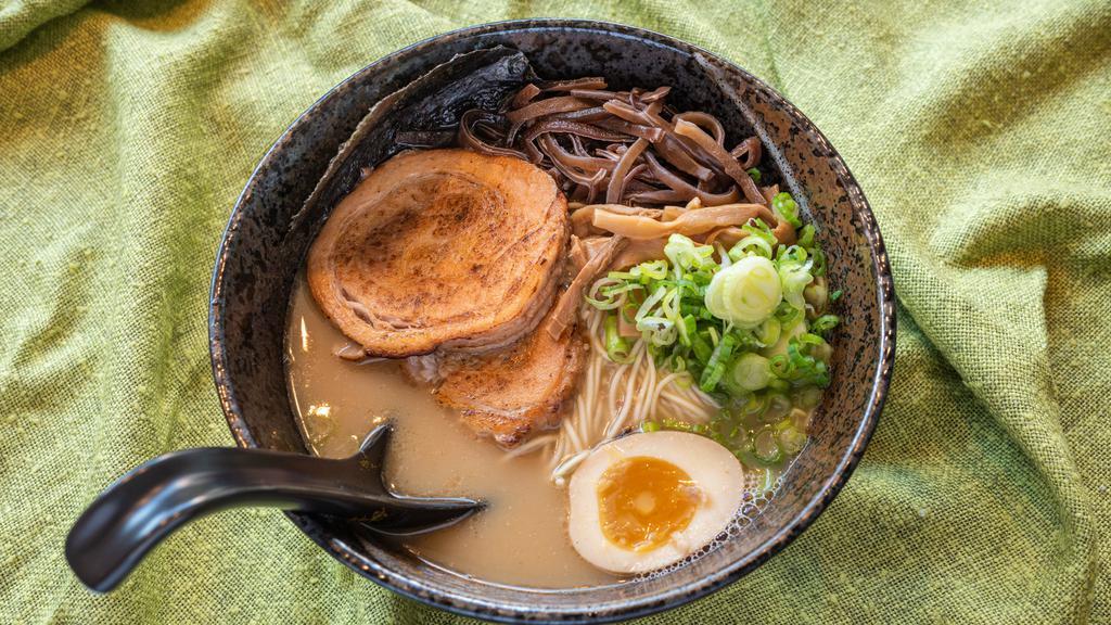 Tonkotsu · Pork broth with shoyu, dashi, pork belly chashu, thin noodles, marinated soft boiled egg, wood ear mushrooms, bamboo shoots, roasted black garlic oil, garnished with scallions, and nori.