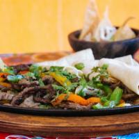 Steak Fajitas · With red and green peppers, onions, poblanos, guacamole, sour cream and flour tortillas.