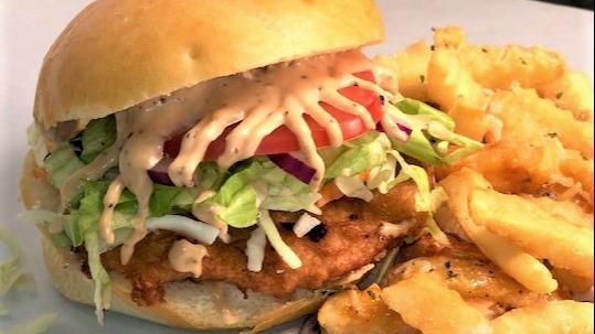 Deep Fried Halibut Burger · Alaskan caught halibut deep-fried with melted Cheddar, house coleslaw, lettuce, tomato, onion, and awesome sauce. Served on our house-made garlic knot dough bun. Served with a generous portion of our famous garlic fries.