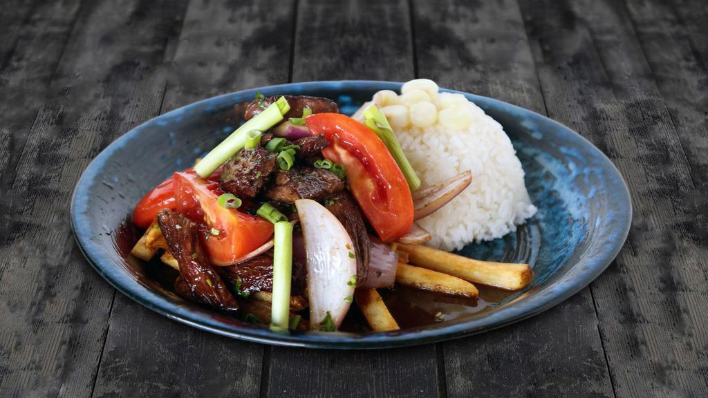 Lomo Saltado · Tender steak sautéed in olive oil with onions and tomatoes. Served over french fries and rice.