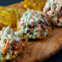 Tostones Trio · Twice-fried smashed green plantains with shredded beef, shredded 
chicken, and black beans. ...