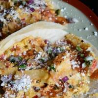 Migas Taco · eggs and house sofrito scrambled with fried tortilla strips, salsa quemada, avocado crema, q...