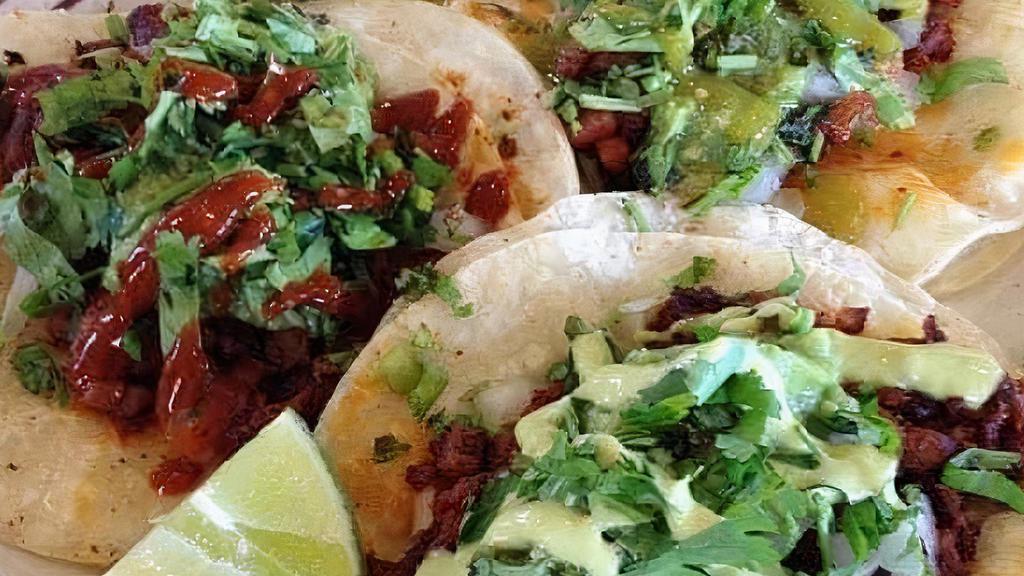 Tacos De Bistec · Three steak tacos per order with cilantro, lemon and sliced onion.