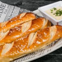 Pretzel Sticks · 3 soft buttery pretzel sticks topped with salt, and served with warm queso cheese for dipping