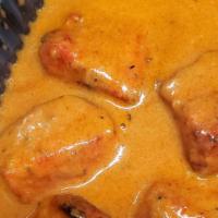 Butter Chicken · Chunks of chicken in velvety butter sauce, served with naan bread, rice and side salad.