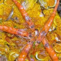 Paella Valenciana · Saffron rice stew made with chicken, mussels, cockle clams, calamari, and shrimp cooked in a...