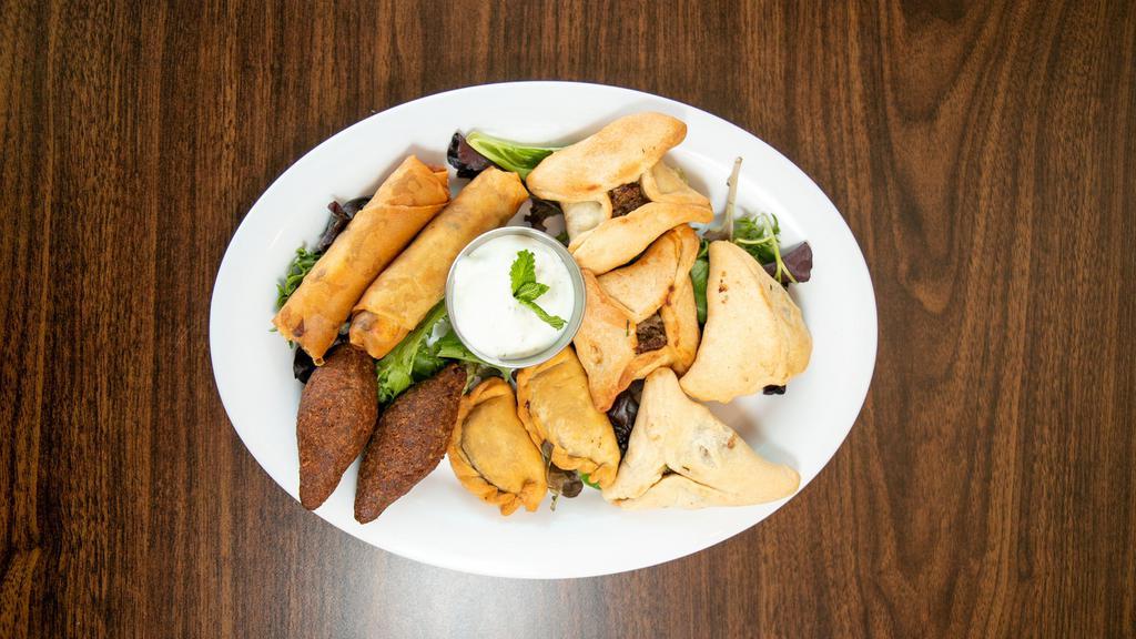 Mezze Sampler  · Vegetarian. Hummus, baba ganoush, four vegetarian grape, leaves, two spinach pie, two falafels. Consuming raw or undercooked meats, poultry, seafood, shellfish, or eggs may increase your risk of foodborne illness. Please advise your server about any food, nuts allergies.