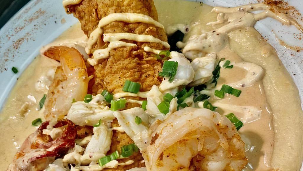 Seafood Catfish · Fried catfish topped with sauteed shrimp, buttered crab and lobster claw meat over spinach and your choice of redskin mashed potatoes or grits all with a Cajun cream drizzle