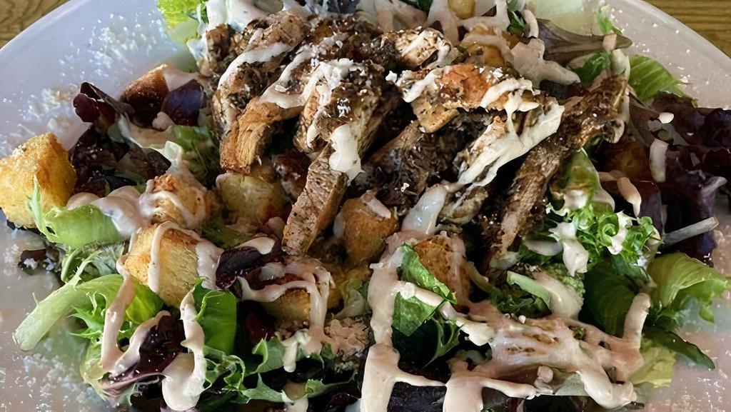 Grilled Jerk Chicken Caesar Salad · Fall greens and romain tossed in caesar dressing topped w/ house made croutons, parmesan cheese and jerk chicken breast