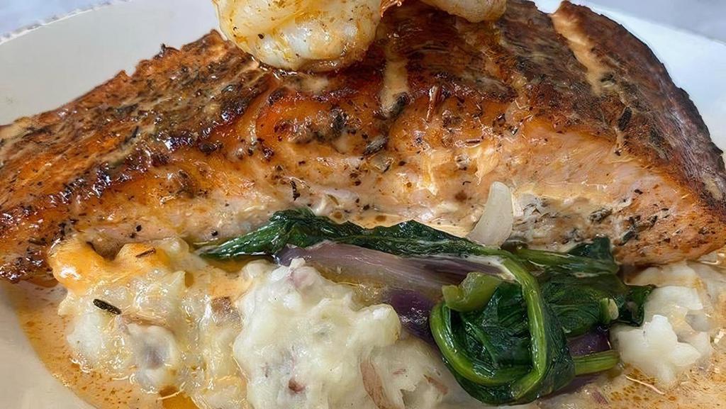 Blackened Salmon · Blackened salmon over your choice of garlic mashed potatoes or cheddar grits  with spinach topped with a Cajun cream sauce