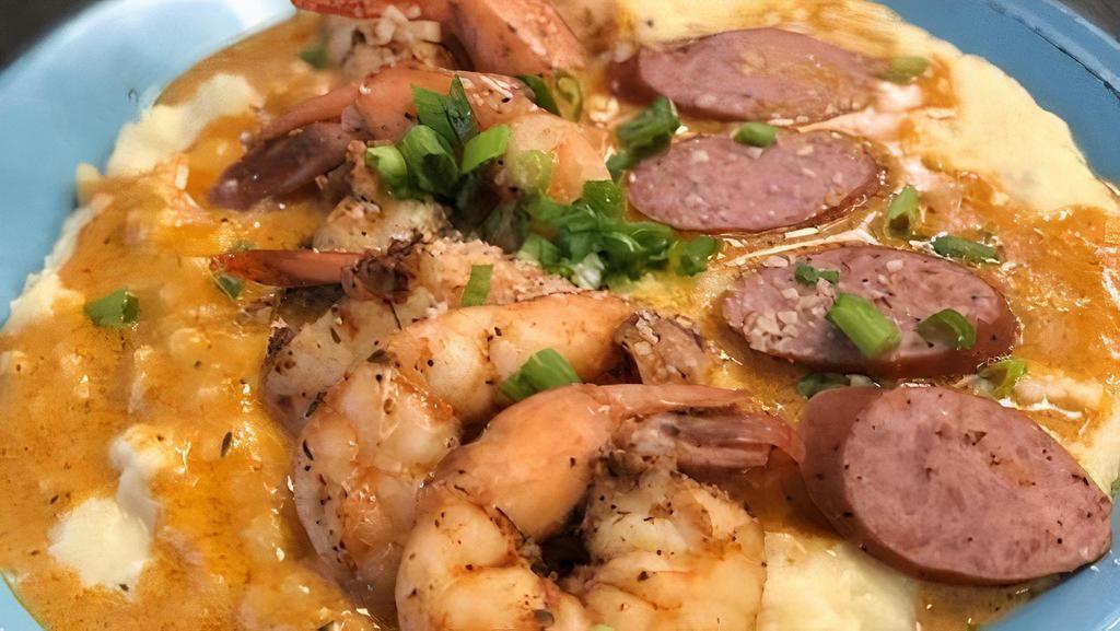 Shrimp And Grits · Six jumbo prawns over creamy cheddar grits topped with Cajun turkey sausage and roasted garlic cream sauce.