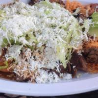 Enchiladas De Mole · Cuatro tortillas fritas con mole poblano y tu opccion de carne con lechuga, queso, crema, ar...