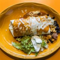 Mojado Burrito · Filled with pork carnitas, black beans and Mexican rice, topped with enchilada sauce and mel...