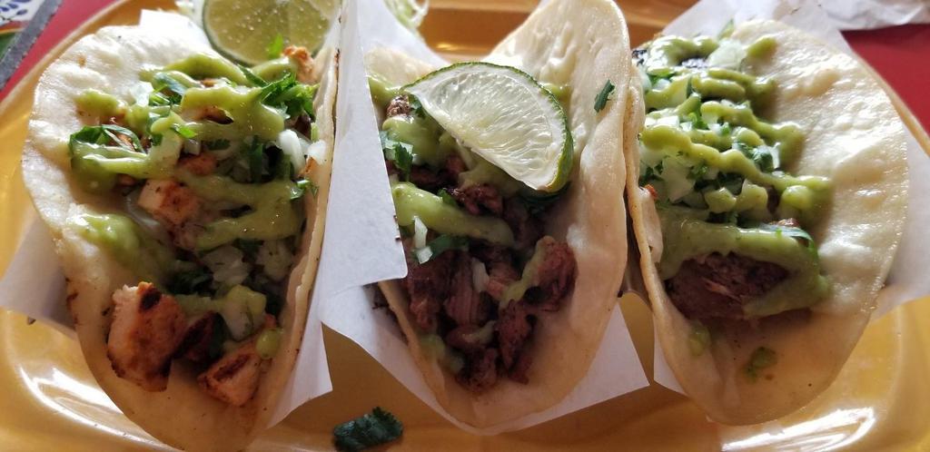 Street Tacos · Three soft corn tortillas filled with chopped grilled steak, chicken, shrimp or tender pork carnitas, onions, cilantro, fresh lime, and avocado tomatillo salsa. (Note: no rice and beans with this dish)