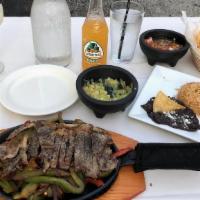 Skirt Steak Fajita · Served in a sizzling plate with corn tortillas, green & red peppers, & onions with rice & be...
