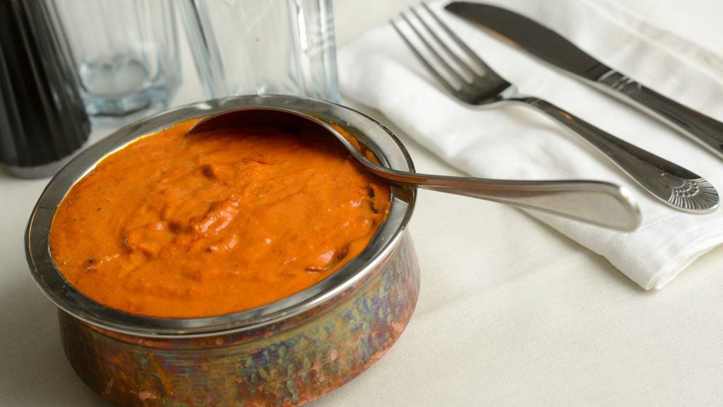 Butter Chicken · Chicken cooked in rich tomato sauce with herbs spices cream and butter then garnished with cream.