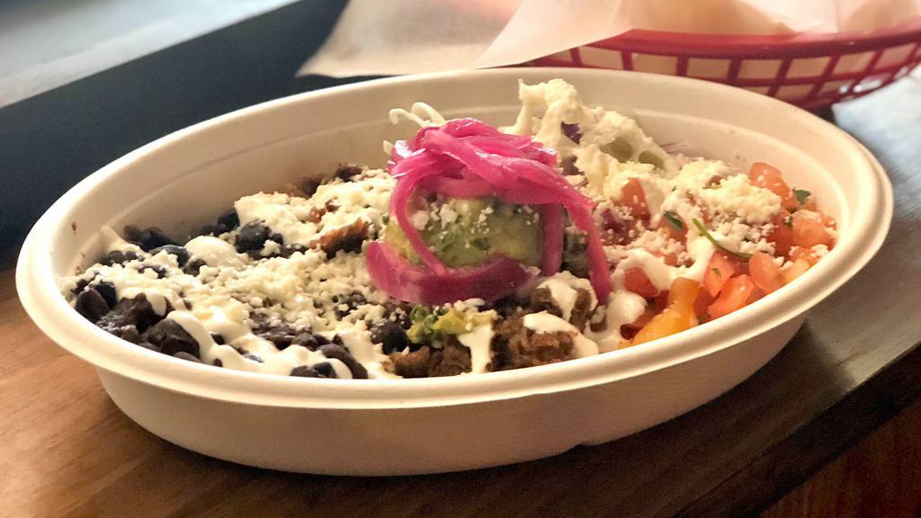 Carne Asada Bowl · Slow roasted beef over red rice with pico de gallo, black beans, pickled red onion, cabbage, queso cotija, and guacamole, sour cream.
