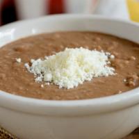 Refried Beans · Refried pinto beans topped with cotija cheese. (Vegetarian)