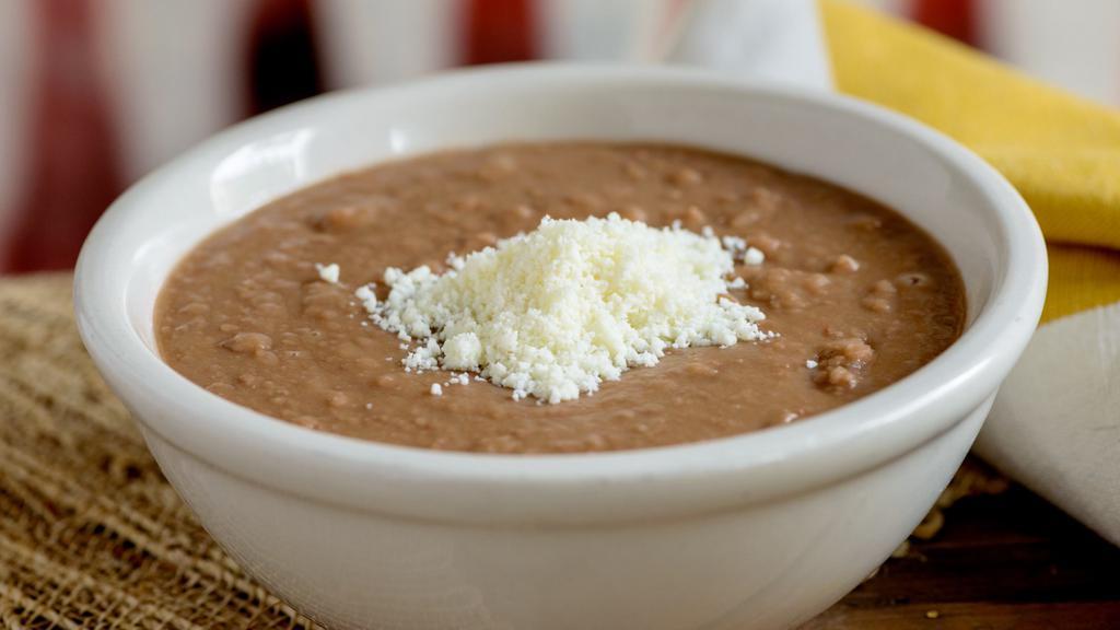Refried Beans · Refried pinto beans topped with cotija cheese. (Vegetarian)