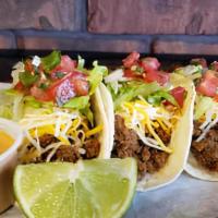 El Taco · 3 soft street tacos served with pico de gallo, lettuce, shredded cheese and your choice of f...