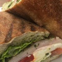 Turkey Tuscana · Turkey breast with pesto spread, lettuce, tomatoes, roasted peppers, caramelized onions, and...